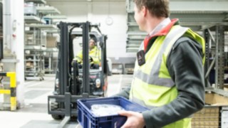 Die Portable Unit warnt Personen durch Tonsignale Person auf dem Firmengelände mit einer Portable Unit am Körper.