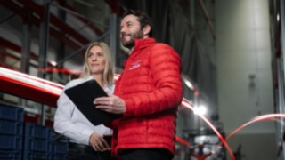 myLinde lässt sich flexibel an die Anforderungen Ihres Unternehmens anpassen. Ein Mann in roter Jacke von Linde MH und eine Frau mit weißem Hemd stehen in einem Warenhaus und schauen in die Ferne.
